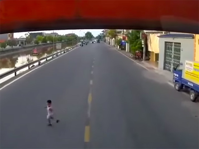 Thót tim cảnh em bé chạy sang đường băng ngang đầu xe tải