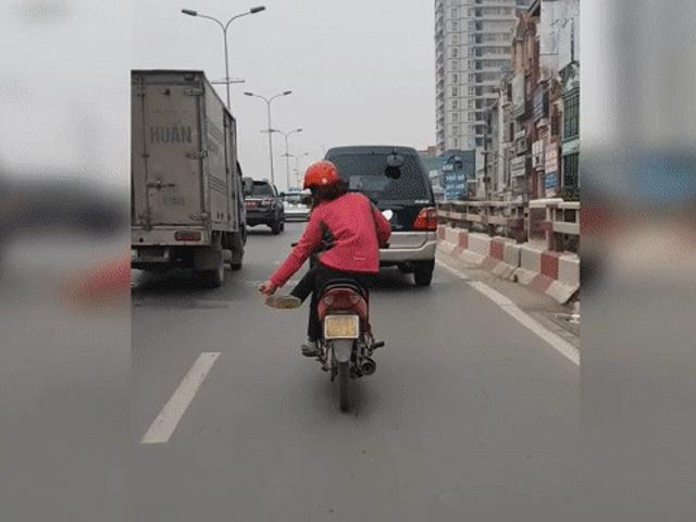 Clip: Người phụ nữ vắt chéo chân lạng lách trên phố Hà Nội gây sốc