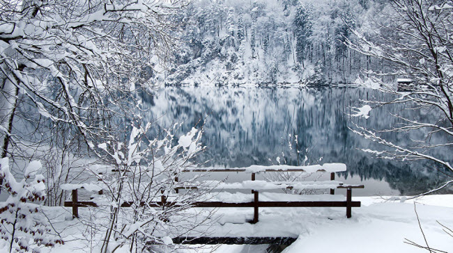 Mặt hồ tĩnh lặng như gương trong một công viên ở Alterschrofen, Bavaria, Đức.