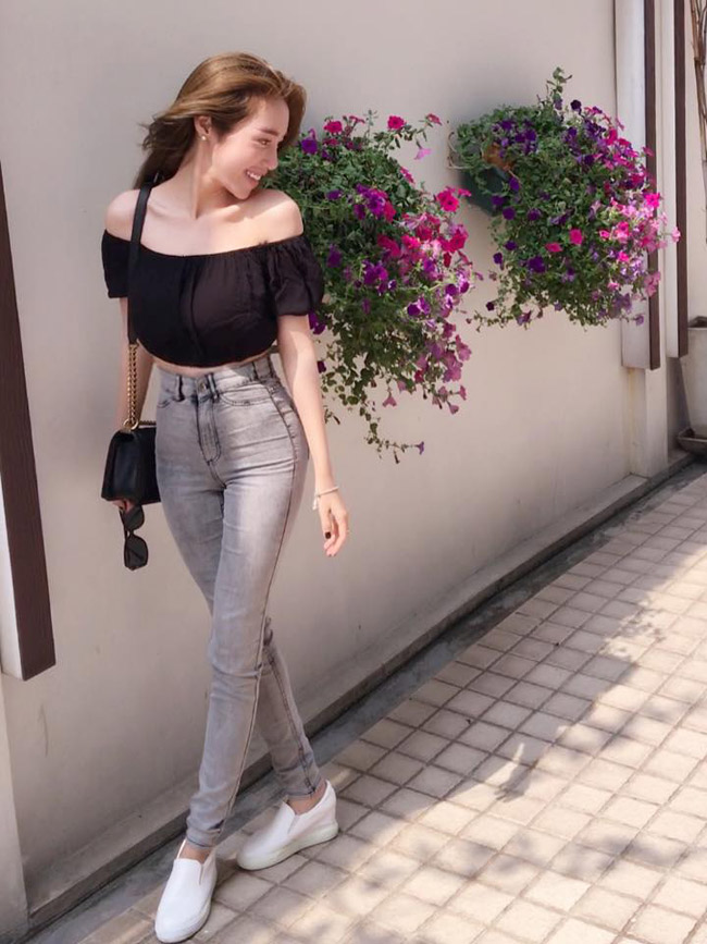 Cô nàng ăn vận đơn giản: áo croptop trễ vai và quần jeans bó sát nhưng vẫn có thể khoe &#34;triệt để&#34; cơ thể hấp dẫn của mình khi tạo dáng bên dàn hoa.&nbsp;