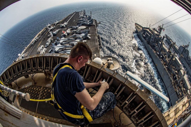 Binh sĩ sửa chữa hệ thống ăng-ten trên tàu sân bay USS Dwight D. Eisenhower hoạt động tại vịnh Ba Tư.