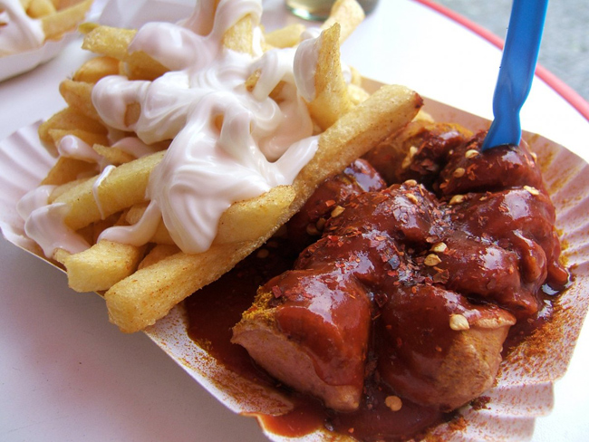 Đức -&nbsp;Currywurst: Người Đức vô cùng yêu thích món Currywurst của mình. Món xúc xích thơm phức được rưới nước sốt cà chua thật đậm lên trên, rắc chút bột cà ri và ăn kèm với khoai tây chiên giòn.
