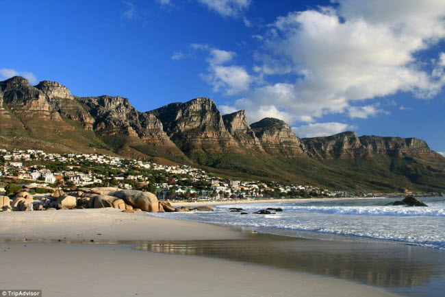 Tới bãi biển Camp&#39;s Bay ở Western Cape, Nam Phi, du khách có thể vừa tắm biển vừa ngắm cảnh núi hùng vĩ phía sau. Khu du lịch này cùng có nhiều nhà hàng và quán bar để bạn trải nghiệm.