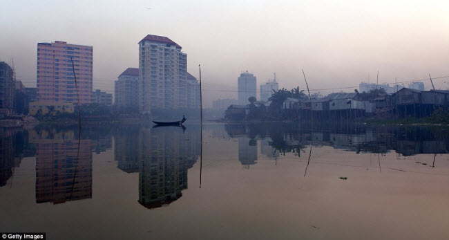 Phía trái của hồ Gulshan ở Dhaka, Bangladesh, là các chung cư cao tầng đối lập với những ngôi nhà lụp xụp ở phía bên phải.