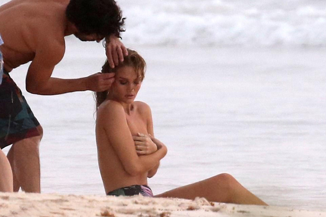 Là một người mẫu, bà xã của tài tử Jason Statham không ngại để một nhân viên nam sửa lại tóc trong tình trạng bán nude, lấy tay che ngực.