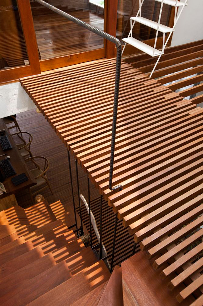 Hành lang cũng được sử dụng hệ lam gỗ để ánh sáng có thể len lỏi xuống các không gian phía dưới