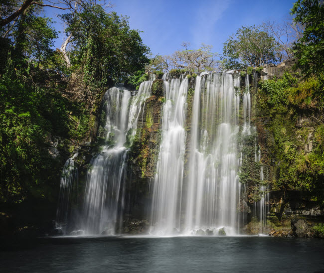 Ánh mặt trời chiếu xuống thác nước bạc trắng ở Guanacaste, Costa Rica.