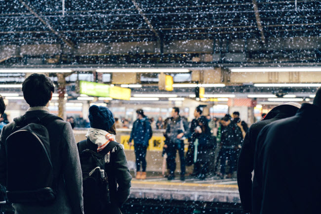 Hành khách chờ tàu điện tại một nhà ga ở Shinjuku Sta, Tokyo.