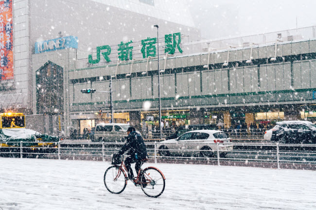Người đàn ông đạp xe dưới mua tuyết ở khu Shinjuku, Tokyo.
