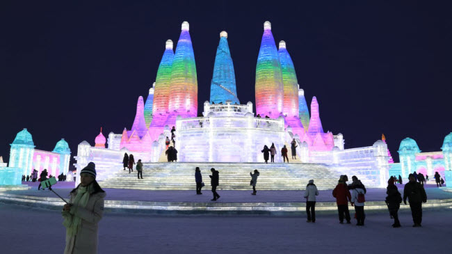 Du khách chiêm ngưỡng những bức tượng băng được chiếu ánh sáng đèn màu tại lễ hội băng đăng quốc tế ở thành phố Cáp Nhĩ Tân, tỉnh Hắc Long Giang, Trung Quốc.