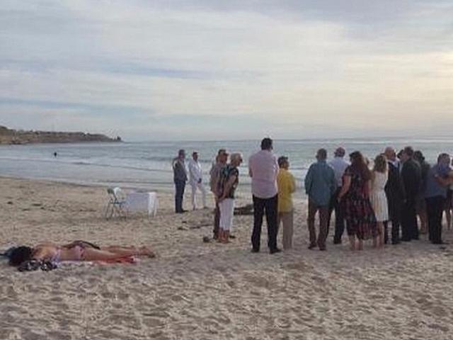 Cô gái bán khỏa thân phơi nắng mặc kệ đám cưới trên bãi biển