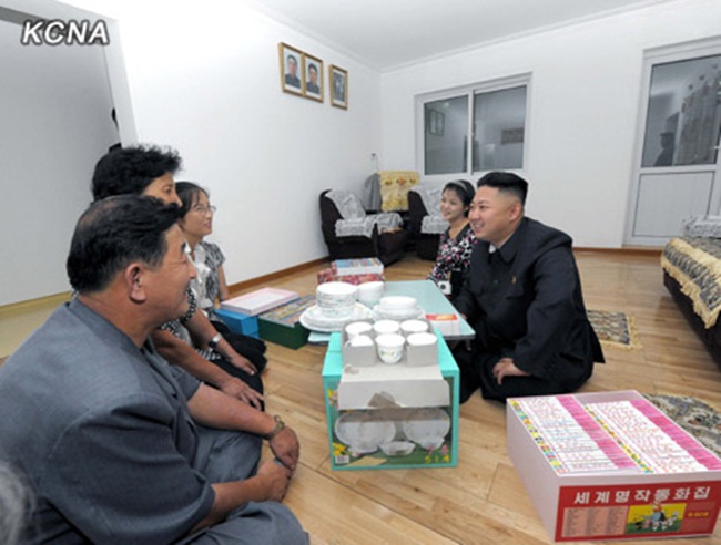 Nhà lãnh đạo Triều Tiên Kim Jong Un và phu nhân trò chuyện với mọi người trong gia đình mới chuyển đến căn hộ mới.