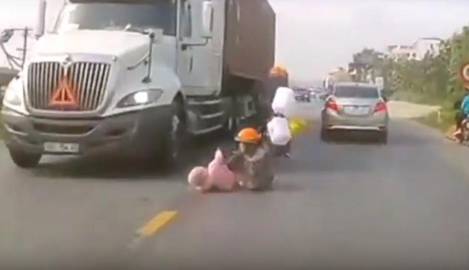 Pha cứu nguy con nhỏ trước bánh xe container của mẹ Việt gây sốt báo ngoại - 1