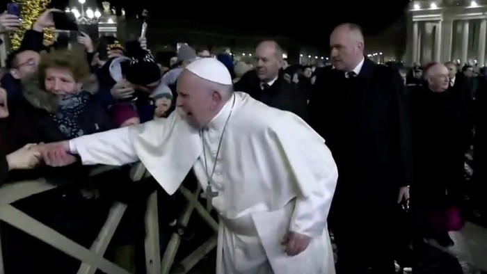 Giáo hoàng tỏ ra khó chịu khi bị người phụ nữ kéo tay một cách thô bạo.