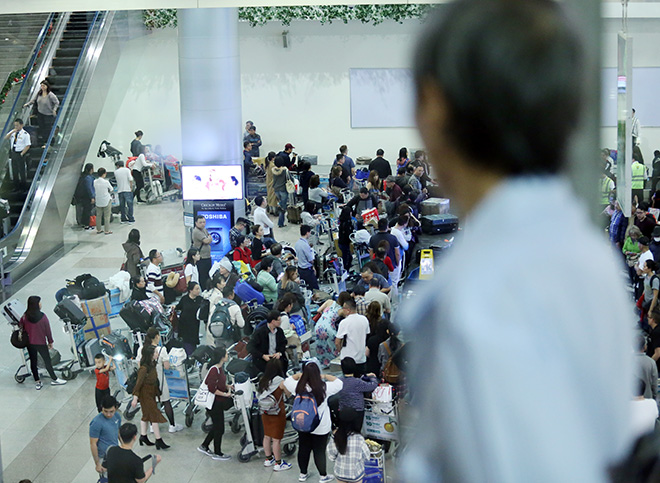 Nhiều người đứng trên khu vực tầng 1 để nhìn vào khu băng chuyền hành lý xem có&nbsp;người thân của mình hay không.