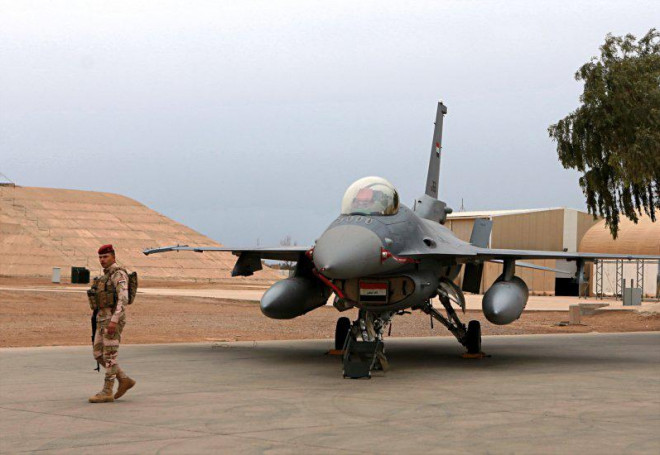 Một binh sĩ Iraq đứng cạnh chiếc F-16 tại căn cứ không quân Balad. Ảnh: AP