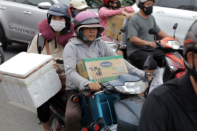 Ghi nhận các phương tiện hầu như chỉ nhích từng chút một trên đường. Rất nhiều người mang ba lô, hành lý và quà Tết trên đường ra bến xe miền Đông mệt mỏi, bơ phờ vì kẹt xe.