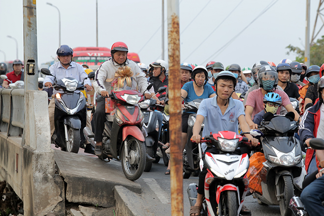 &nbsp;Nhiều người chạy lên khu vực lối đi dành cho người đi bộ trên cầu Bình Triệu để tránh kẹt xe. Tuy nhiên, khi vừa xuống dốc cầu, một người loạng choạng tay lái vì độ dốc cao.