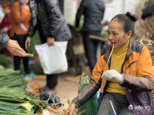 Chị chủ hàng vừa chẻ lạt vừa bán lá, năm nay lá dong được giá nên hầu như những chủ sạp không phải vất vả bán hàng như những năm trước