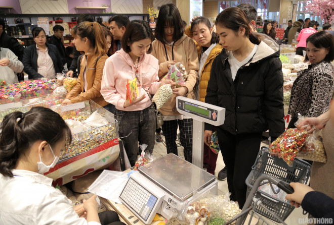 Thu hút khách hàng hơn cả là các loại bánh, kẹo, mứt... Ở quầy cân, nhân viên làm việc không ngơi tay.