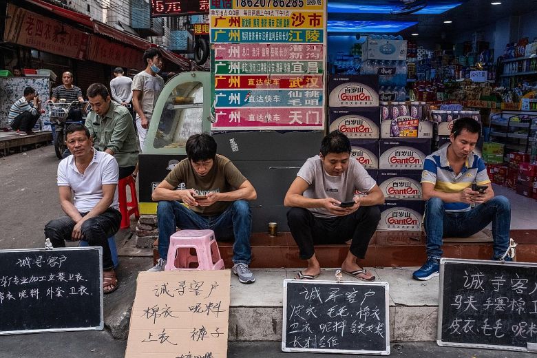 Nhân viên một xí nghiệp dệt&nbsp;tại Quảng Châu trưng bảng "tuyển khách hàng" ngoài phố (Ảnh: New York Times)