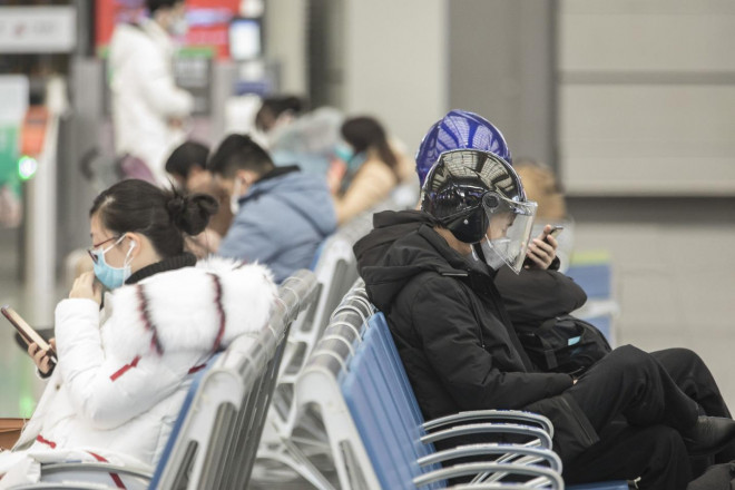 Các hành khách đeo khẩu trang đang chờ tại một trạm đường sắt ở TP Thượng Hải – Trung Quốc. Ảnh: Bloomberg