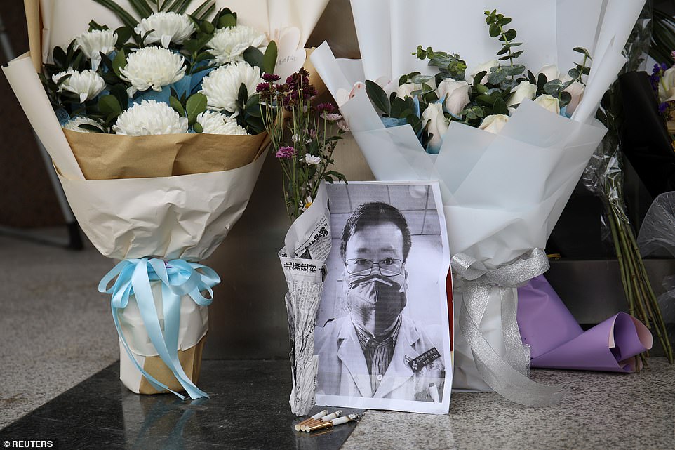 Hoa và ảnh bác sĩ Lý Văn Lượng được đặt trước bệnh viện nơi anh qua đời (ảnh: Dailymail)