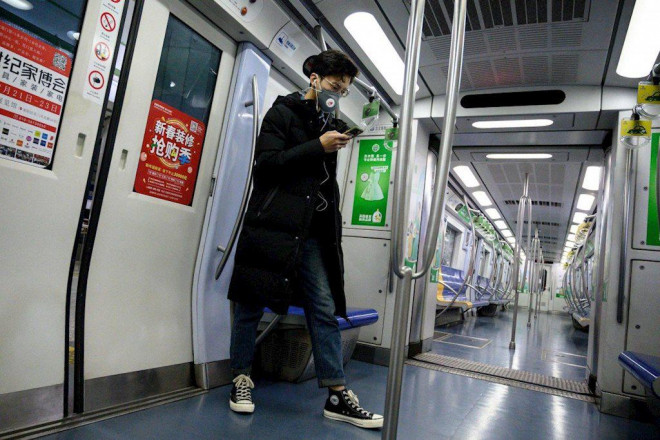 Người đàn ông đeo khẩu trang trên một chuyến tàu tại Bắc Kinh hôm 28/1. Ảnh: AFP