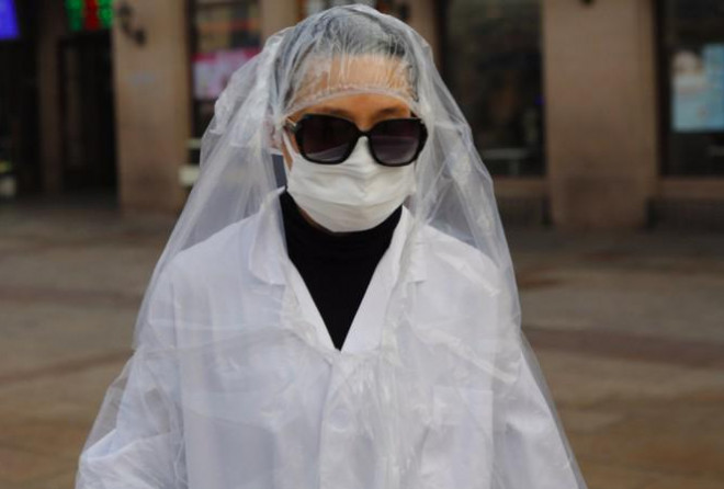 Một hành khách mặc áo nylon kín người đi bên ngoài ga tàu ở Bắc Kinh hôm 11/2ảnh: EPA-EFE