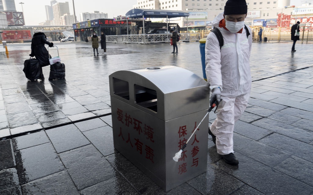 Nhân viên y tế Trung Quốc phun thuốc khử trùng tại nơi công cộng (ảnh: Nytimes)
