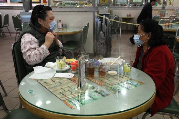 Lo sợ nhiễm Covid-19, nhiều nhà hàng Hong Kong đặt tấm chắn trên bàn ăn cho khách. Ảnh: SCMP