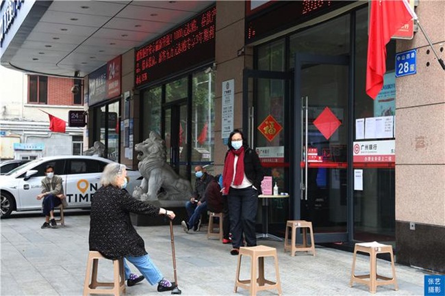 Hình ảnh chụp người Quảng Châu đến giao dịch ở một ngân hàng. Trong khi chờ đợi, các khách hàng được sắp xếp ngồi cách nhau 1m.