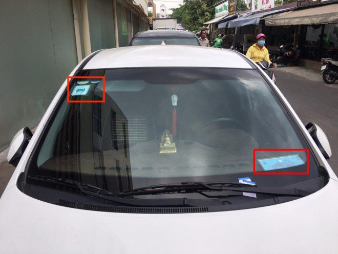 Một xe GrabCar gắn phù hiệu Xe hợp đồng và tem GrabCar ở kính xe. Ảnh: Grab