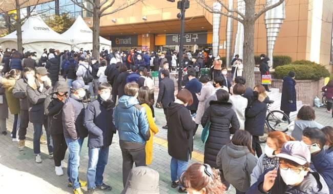 Dòng người xếp hàng dài chờ đợi trong sự trật tự đến lượt vào mua khẩu trang tại siêu thị E-Store tại Daegu.