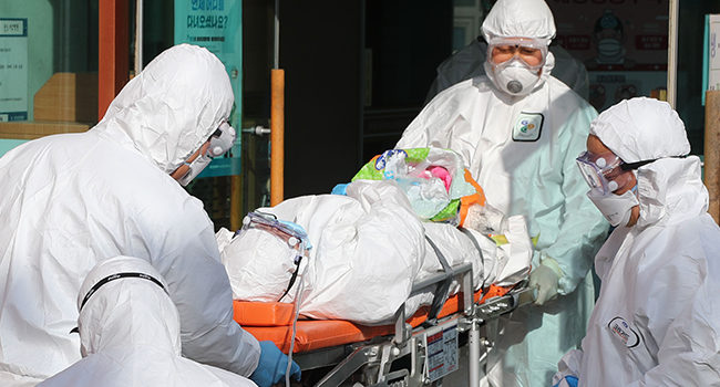Các nhân viên y tế vận chuyển một người nghi nhiễm virus Corona.