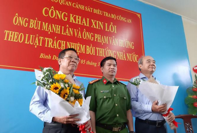 Thượng tá Đặng Trọng Cường tặng hoa cho ông Lân (trái) và Hướng (phải) tại buổi công khai xin lỗi. Ảnh: Tân Châu