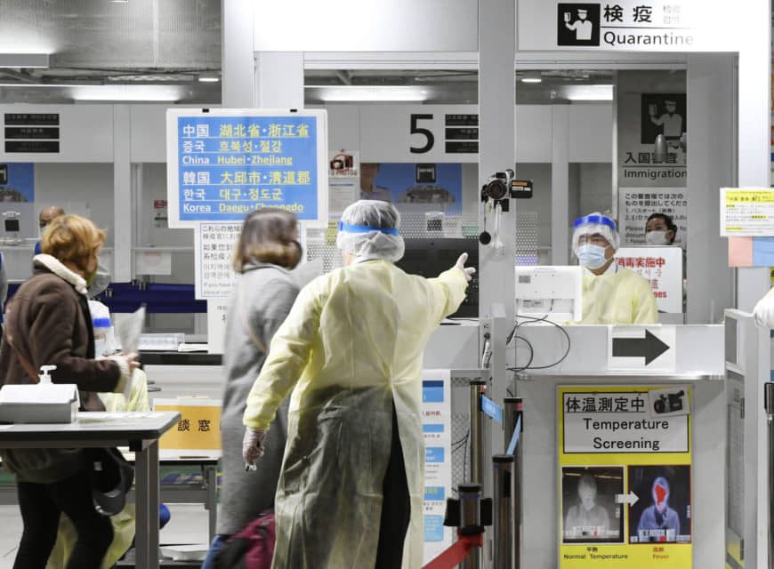 Nhân viên y tế Nhật Bản hướng dẫn khách nhập cảnh từ Hàn Quốc.