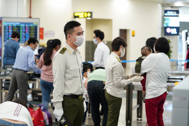 Nhân viên an ninh trực các cổng cửa Nhà ga tại các Cảng hàng không, sân bay có trách nhiệm nhắc nhở, khuyến cáo hành khách phải đeo khẩu trang - Ảnh: Phan Công