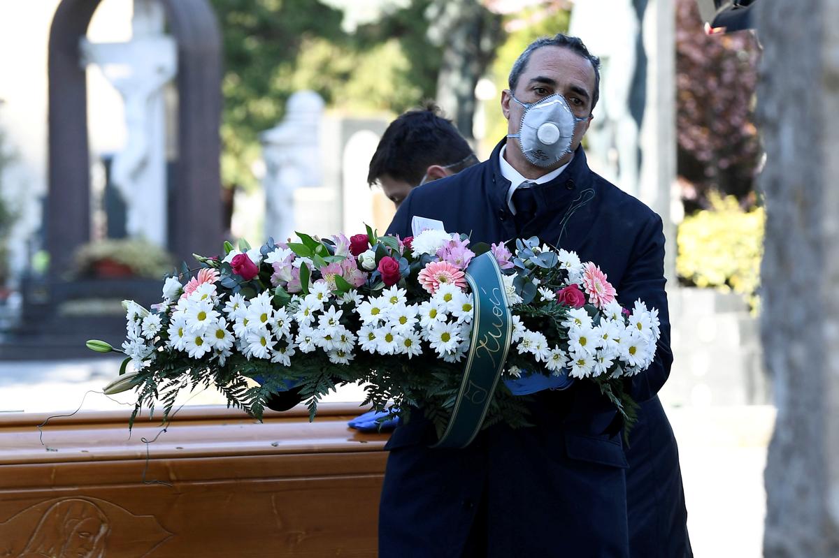 Một nhân viên tang lễ đeo khẩu trang tại Ý (ảnh: Reuters)