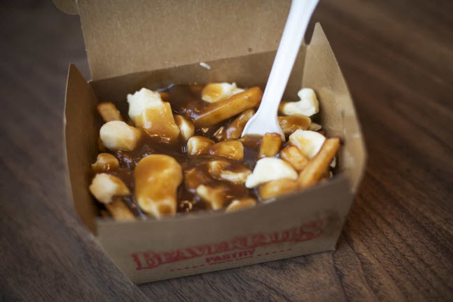 Poutine, Canada: Thành phần chính của món ăn này là khoai tây chiên được cho thêm thịt lợn xông khói, thịt gà hay xúc xích cùng nước xốt.