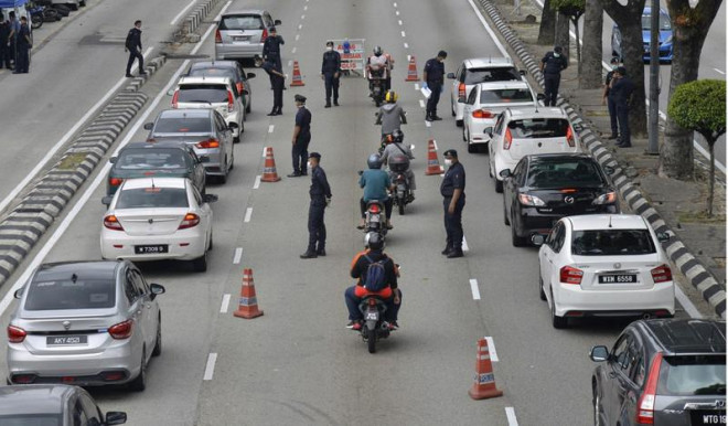 Cảnh sát kiểm soát đi lại người dân trên đường phố thủ đô Kuala Lumpur (Malaysia). Ảnh: AP