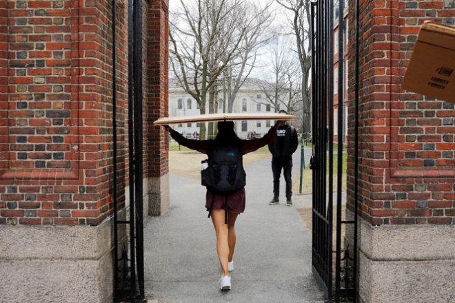 Một sinh viên mang hộp đến ký túc xá của cô tại Đại học Harvard,&nbsp; sau khi trường yêu cầu sinh viên không trở lại trường sau kỳ nghỉ xuân. Ảnh: Reuters