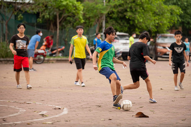 &nbsp;Thanh niên và trẻ nhỏ không đeo khẩu trang thoải mái đá bóng nơi công cộng đông người