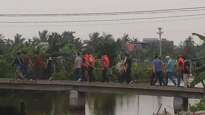 Nguyễn Sỹ Thắng (mặc áo phao, bị buộc dây) được công an dẫn giải để thực nghiệm quá trình gây án.