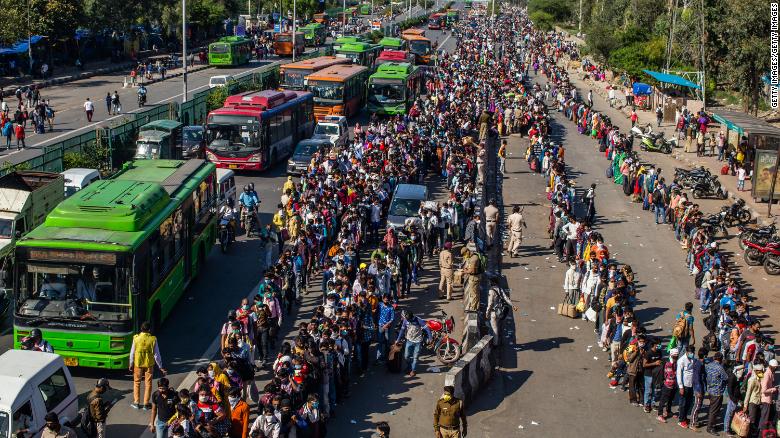 Hàng dài lao động nghèo Ấn Độ xếp hàng chờ xe bus hôm 28/3 ở ngoại ô thủ đô New Delhi để được về quê. Ảnh: Getty