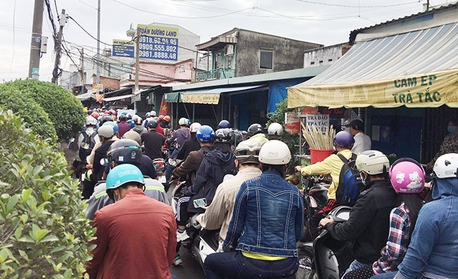 Dòng xe máy xếp hàng dài chờ qua phà kéo dài gần 1km. “Đi chơi dịp nghỉ Tết mà mệt quá. Chưa rời khỏi Sài Gòn mà đã dính kẹt xe thế này. Chờ qua phà như cực hình vậy”, một phụ nữ tên Hằng chia sẻ.