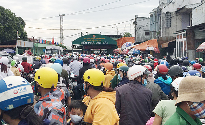 Người đi xe máy mệt mỏi vì chờ qua phà quá lâu. Nhiều gia đình chạy xe máy bồng bế theo con nhỏ, lỉnh kỉnh đủ loại đồ đạc, nhích từng chút chờ mua vé.