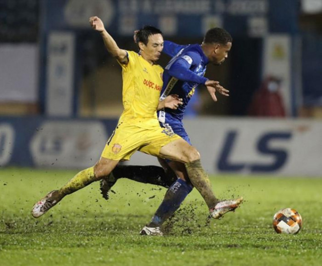 Phùng Văn Nhiên (trái) trong pha tranh chấp với ngoại binh V-League