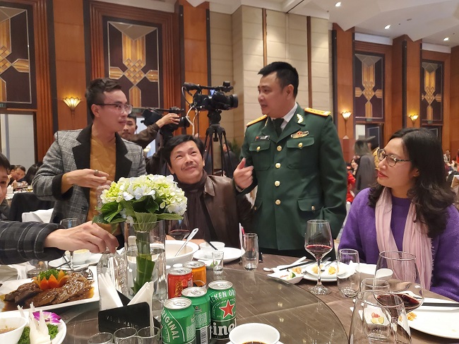 Diễn viên Trung Anh và nghệ sĩ Tự Long ngồi cạnh nhau trong bữa tiệc.

