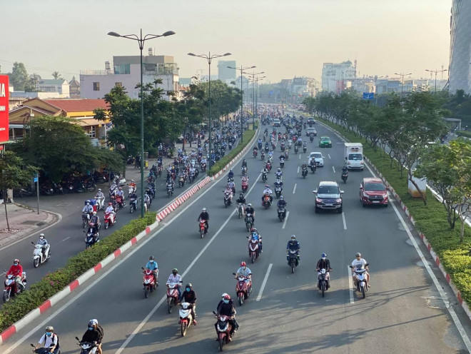 Người dân di chuyển trên đường Phạm Văn Đồng sáng sớm 8-1
